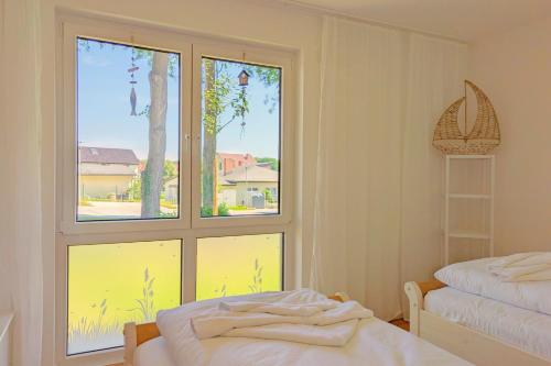 a room with a large window and a bed and a window at Bernsteinquartier Ferienwohnung Blaues Fenster in Kölpinsee