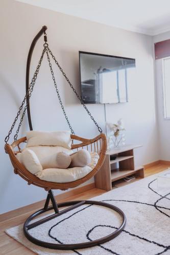 a swing chair with pillows in a living room at 3 bedroom apartment Cozy experience Lisbon in Mealhada