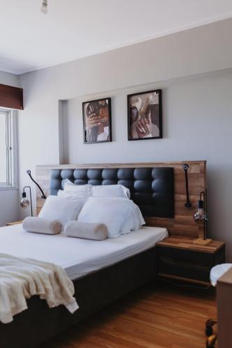 a bedroom with a large bed with two pictures on the wall at 3 bedroom apartment Cozy experience Lisbon in Mealhada