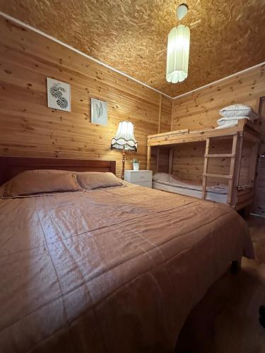 a bedroom with a bed in a wooden room at Mazligzdiņa in Višķi