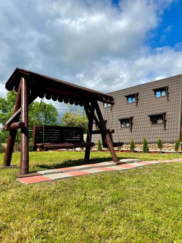 a bench in a park in front of a building at Cabana Galaxy A Frame by Cabanele Galaxy in Cucuteni