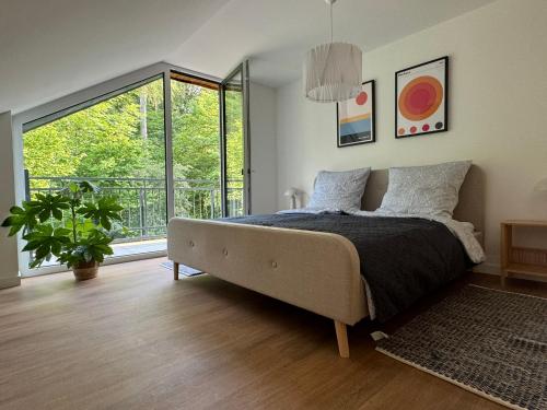 a bedroom with a bed and a large window at Stilvolles Apartment mit Waldblick in Bad Bentheim