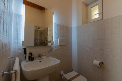 a bathroom with a sink and a toilet and a mirror at B&B Palazzo Vittoria in Bisceglie