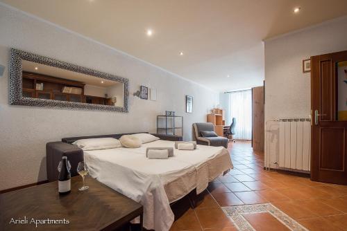 een slaapkamer met een bed, een tafel en een spiegel bij Arieli Apartments Izola in Izola