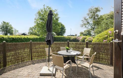 a table and chairs with an umbrella on a patio at Cozy Home In Juelsminde With Wifi in Juelsminde