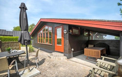a small cabin with a table and an umbrella at Cozy Home In Juelsminde With Wifi in Juelsminde