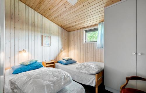 two beds in a small room with wooden walls at Cozy Home In Juelsminde With Wifi in Juelsminde