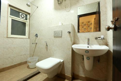 uma casa de banho com um lavatório e um WC em Arkwood Residency B & B At Airport em Nova Deli