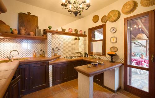 cocina con armarios de madera, fregadero y ventana en Villa Eugenia, en Favazzina