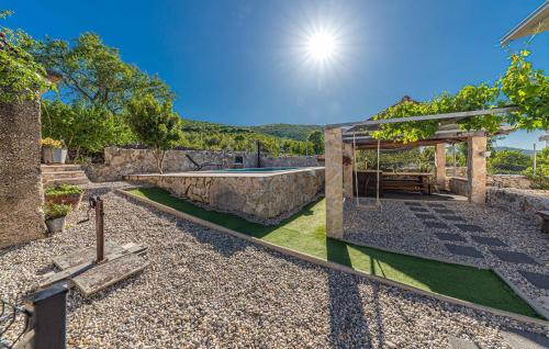 a stone house with a swimming pool and a garden at Nice Home In Trolokve in Prgomet