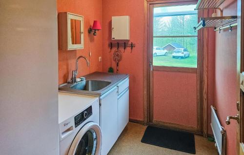 a kitchen with a washing machine and a sink at Awesome Home In Brånalt With Kitchen in Knäred