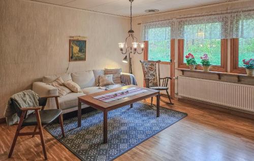 a living room with a couch and a table at Awesome Home In Brånalt With Kitchen in Knäred