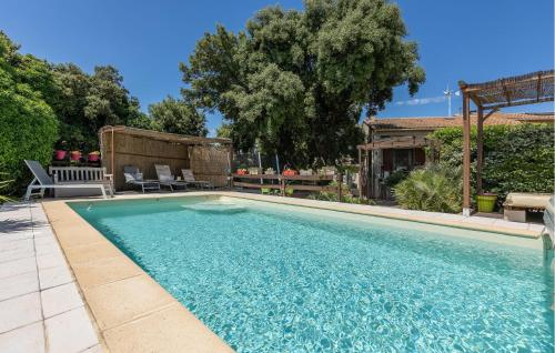 a swimming pool with blue water in a yard at Awesome Home In Bédarrides in Bédarrides