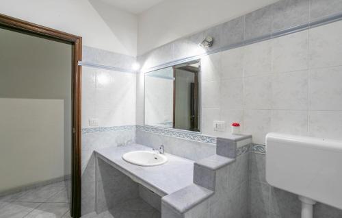 a white bathroom with a sink and a mirror at 2 Bedroom Awesome Apartment In Messina in Briga Marina