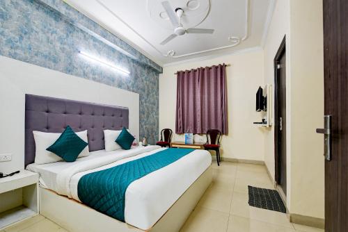 sypialnia z dużym łóżkiem z niebieskim zagłówkiem w obiekcie Arkwood Residency B & B At Airport w Nowym Delhi