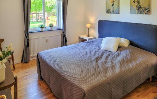 Un dormitorio con una cama azul y una ventana en Pet Friendly Apartment In Hyltebruk With Wifi en Hyltebruk