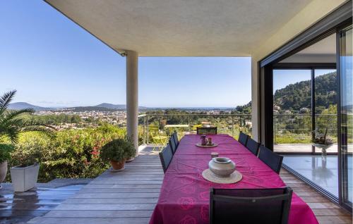 une salle à manger avec une table violette sur une terrasse dans l'établissement Nice Home In La Valette Du Var, à La Valette-du-Var
