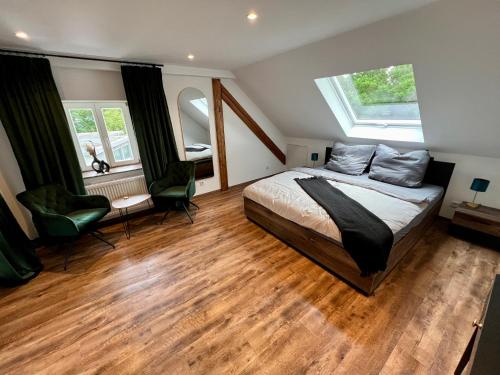 a bedroom with a bed and a desk and two windows at Altes Eichamt Schweinfurt in Schweinfurt