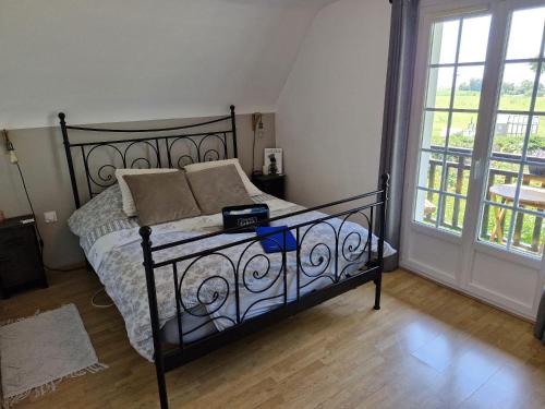 a bedroom with a bed with a wrought iron frame at Chambre d'hôte proche d'Étretat in Saint-Jouin-Bruneval