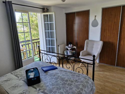 une chambre avec un lit, une chaise et une fenêtre dans l'établissement Chambre d'hôte proche d'Étretat, à Saint-Jouin-Bruneval