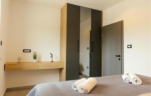 1 dormitorio con 1 cama con toallas en Cozy Home In Gornji Prolosac With Kitchen en Gornji Proložac