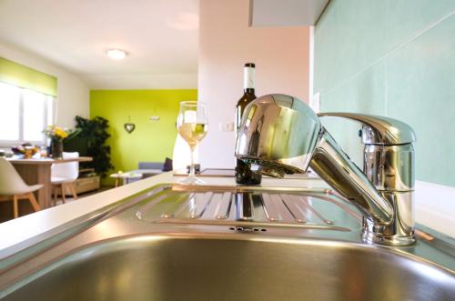 a kitchen sink with a glass of wine at AS apartmani "Pistachio" in Peroj