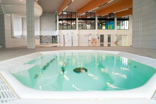 una gran piscina de agua azul en un edificio en Beautiful Top Floor Seaview Studio Apartment B'berge-Bruges en Blankenberge