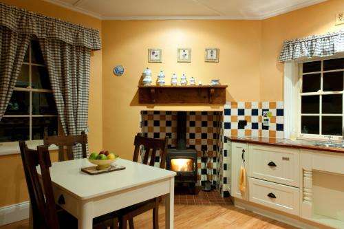 - une cuisine avec une cheminée, une table et une cuisinière dans l'établissement Linfield Cottage, à Williamstown