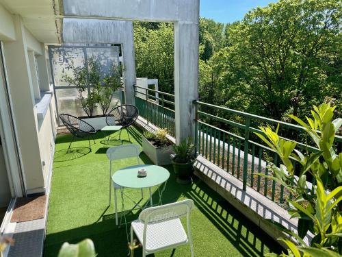 un balcón con mesa y sillas. en Appartement avec terrasse et parking gratuit accolé en Montbéliard