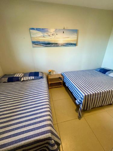 two beds sitting next to each other in a room at Kite house - prox do Cumbuco in Caucaia