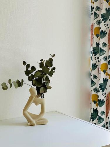 a vase with a plant in it on a shelf at Appartement la Citadelle in Laon