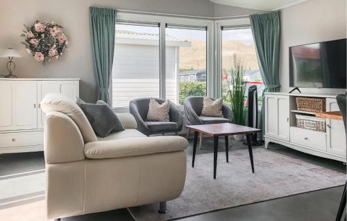 a living room with a couch and chairs and a tv at Lovely Stacaravan In Julianadorp in Julianadorp