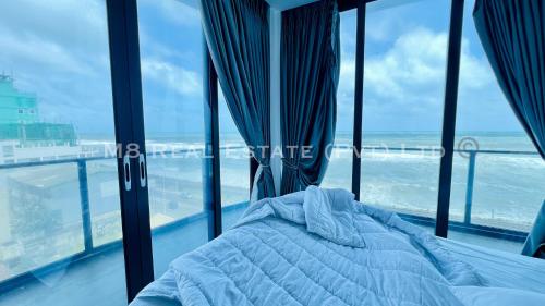 a bed in a room with a view of the ocean at M8 Ocean King Three Bed Apartment in Cinnamon Gardens