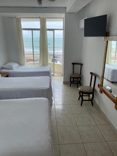 アタカメスにあるHOTEL PAL-MARのベッド2台が備わる海の景色を望むホテルルームです。