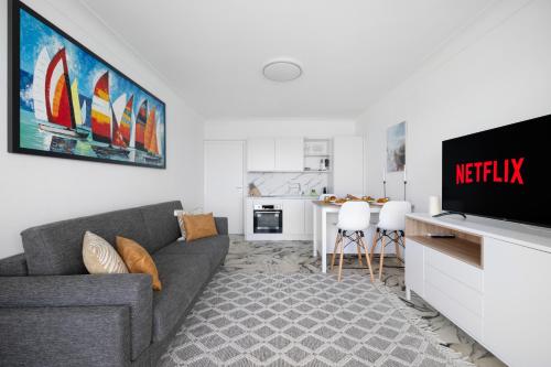 un salon avec un canapé et une télévision dans l'établissement Le COQ Eden - Air conditioning - Seafront, à Roquebrune-Cap-Martin