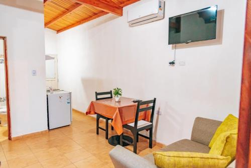 una pequeña sala de estar con mesa y TV. en Cabañas Puertas del Sol en La Rioja