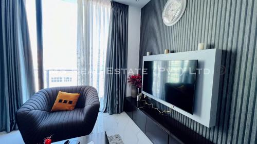 a living room with a tv and a chair at M8 Ocean King Three Bed Apartment in Cinnamon Gardens