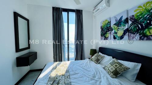 M8 Ocean King Three Bed Apartment في Cinnamon Gardens: غرفة نوم بسرير ونافذة كبيرة
