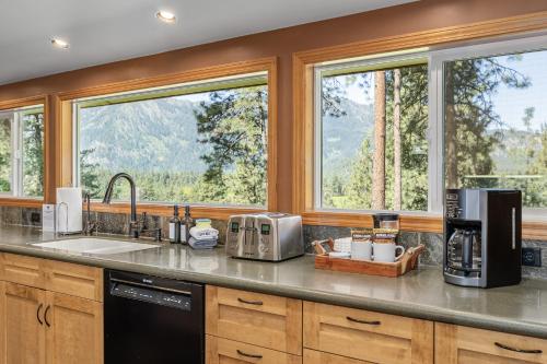 a kitchen with a sink and two windows at River Heights Home cabin in Leavenworth