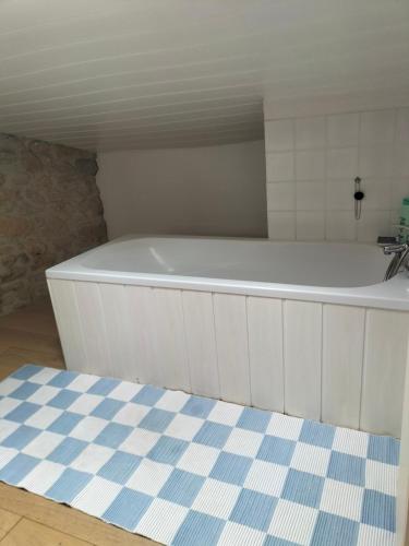 une baignoire blanche dans une salle de bain avec un lavabo dans l'établissement Chambres 2 personnes dans notre maison Girondine, à Saint-Martin-de-Lerm