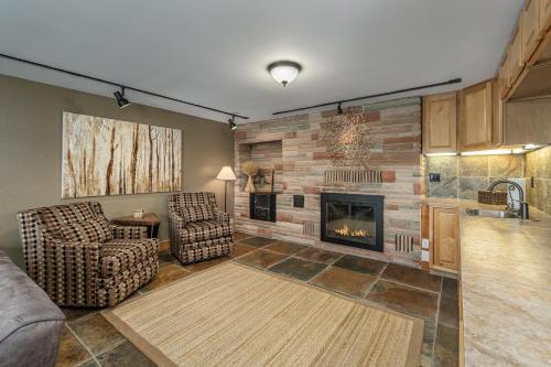 a living room with a fireplace and two chairs at River Heights Home cabin in Leavenworth