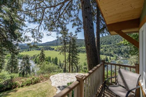 a porch with a chair and a view of a river at River Heights Home cabin in Leavenworth