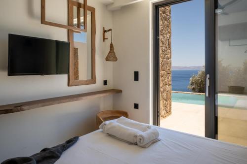 Un dormitorio con una cama y vista al mar. en ArtOikia Luxury Villas, By Hellocrete, en Saktoúria
