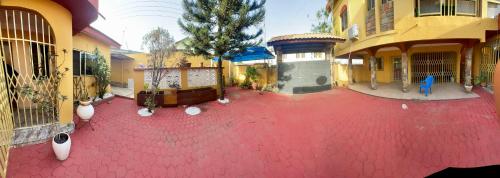 a red floor in a courtyard of a building at Villa de chez nous in North Legon