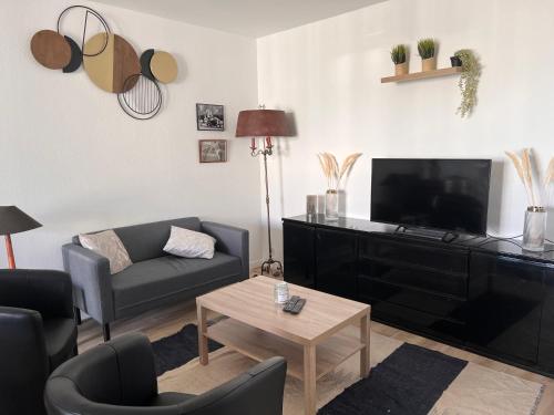 a living room with a couch and a tv at T3 pied de la gare + centre commercial TOUT inclus in Orléans