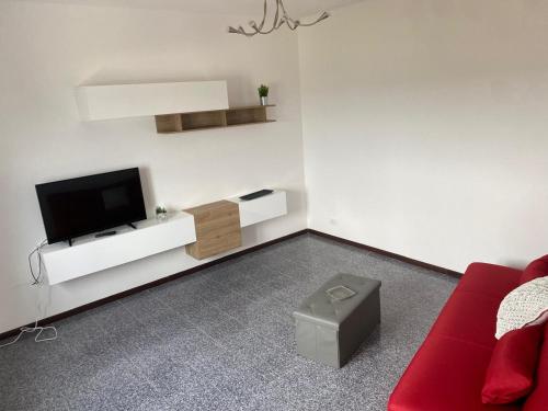 a living room with a tv and a red couch at Nonna Lella in Ripa Teatina
