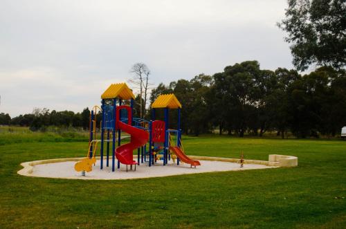 a playground with a slide in a park at Acclaim Swan Valley Tourist Park in West Swan