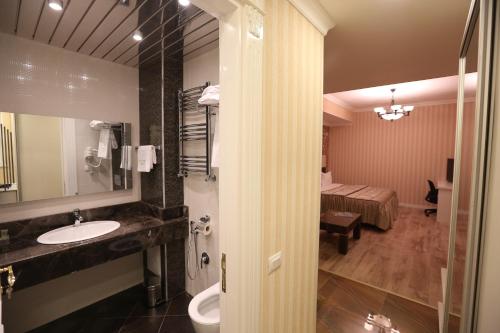 een badkamer met een wastafel, een toilet en een bed bij Old Street Boutique Hotel in Baku