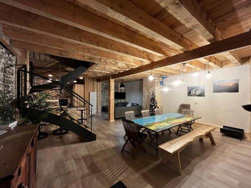 une salle à manger avec une table et un escalier dans l'établissement La Grange de la Gratade, à Rochefort-Montagne