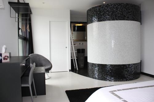 Un dormitorio con una gran pared en blanco y negro. en Un Moment à la Campagne, en Pleuven